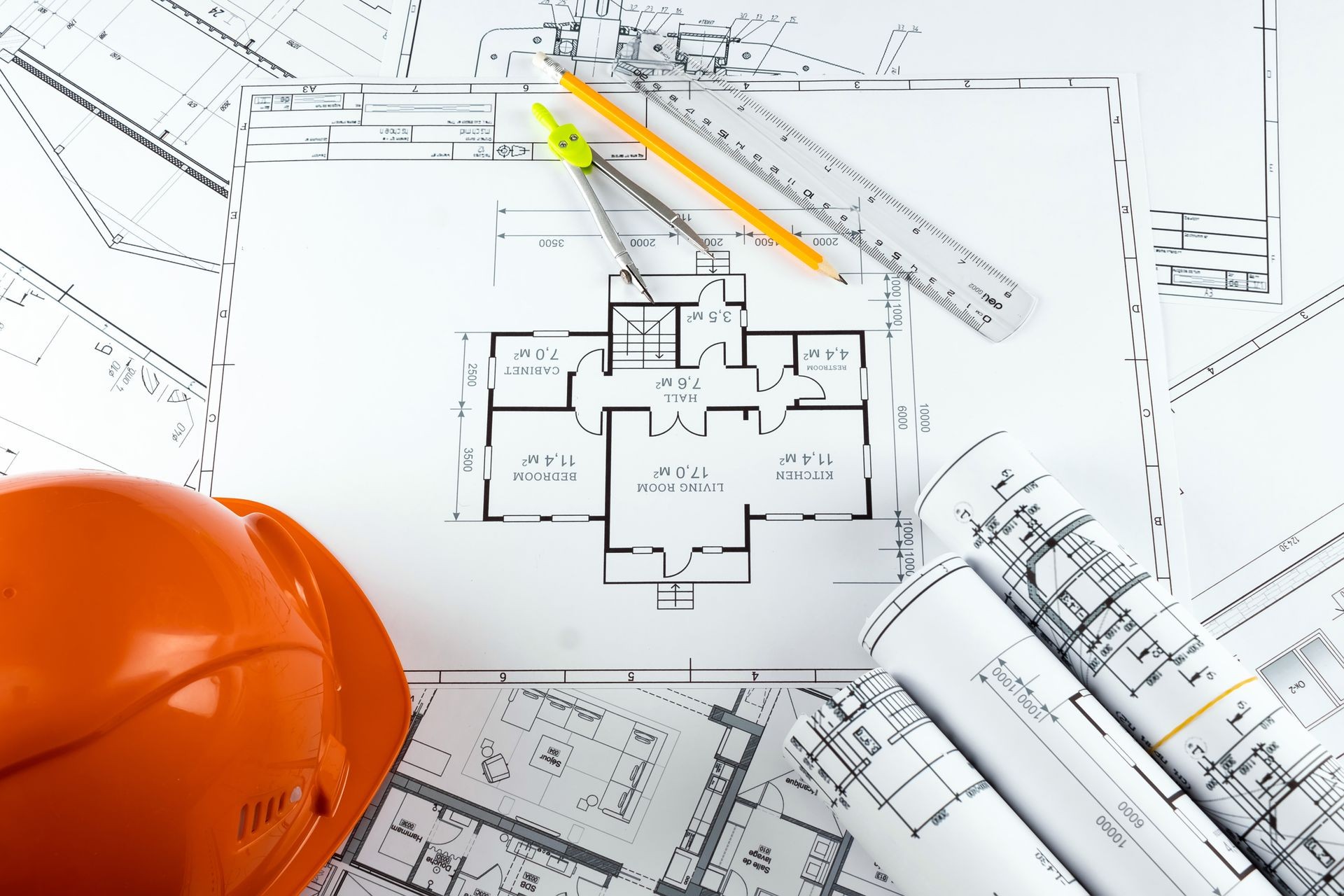 Orange helmet, pencil, architectural construction drawings, tape measure. The concept of architecture, construction, engineering, design. Copy space.